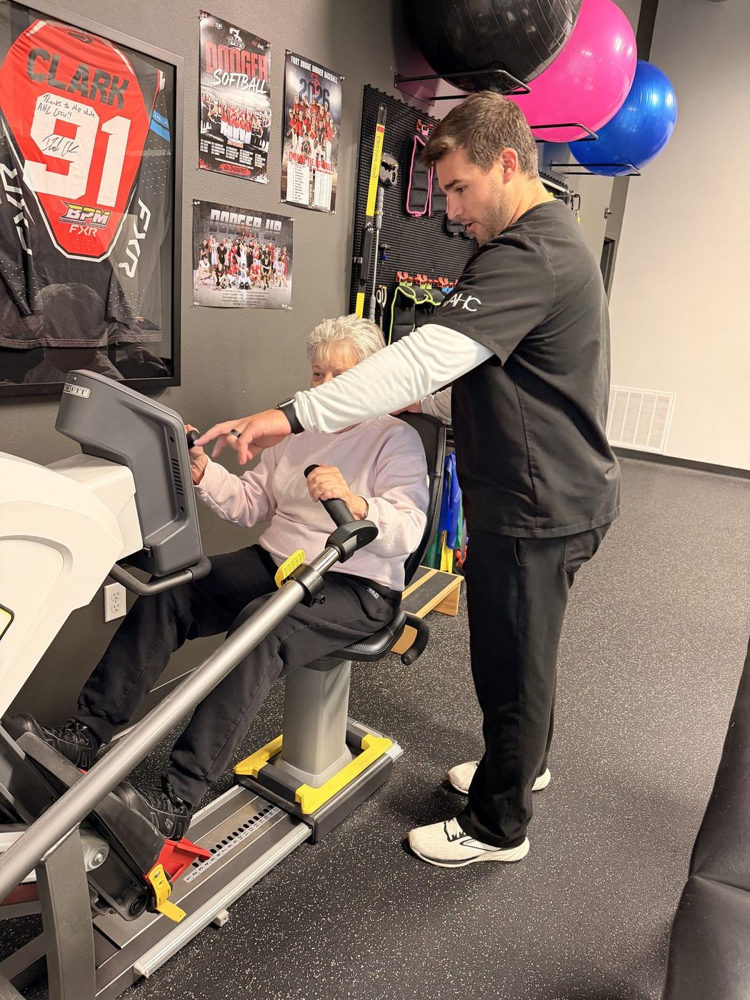 A patient doing rehab on the recumbent stepper with an Active Health Clinics therapist