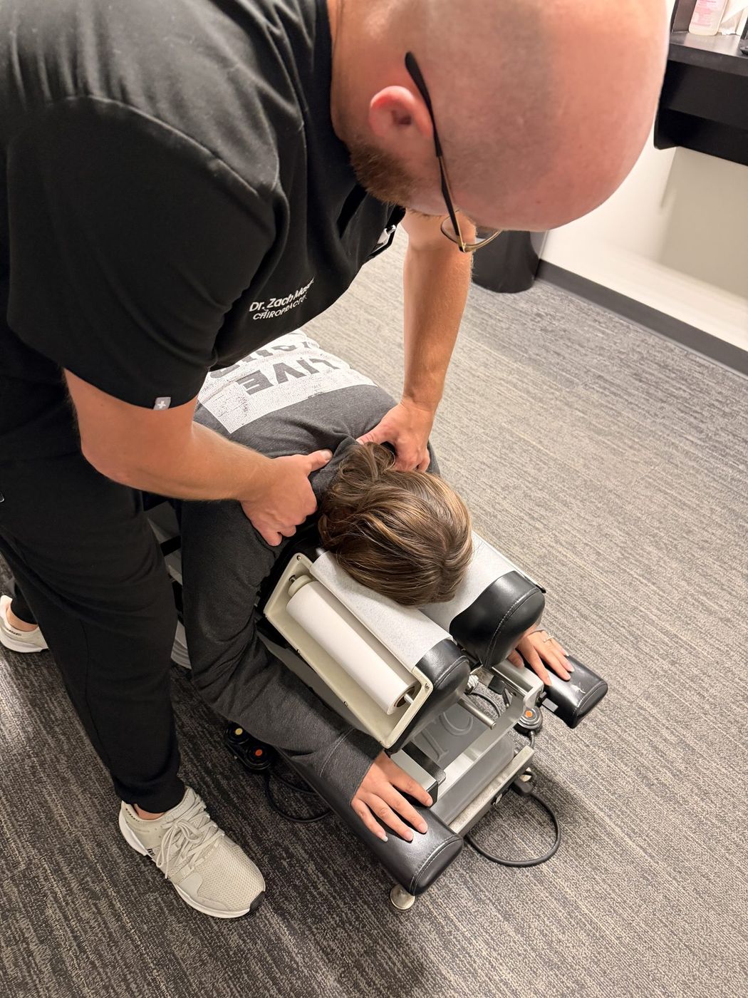 A chiropractor examining a patient's back at Active Health Clinics