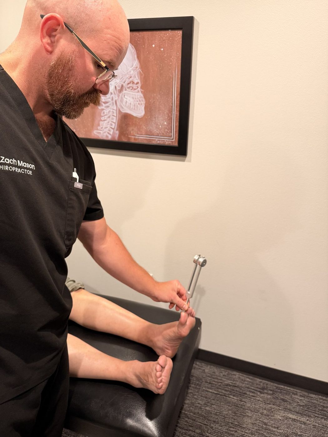 Tuning-fork vibration test checking nerve function in a patient's feet
